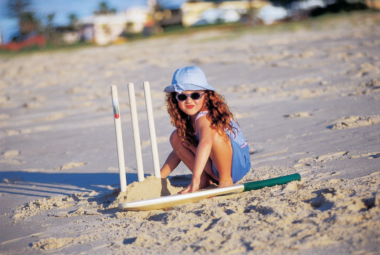 girl with beach cricket set